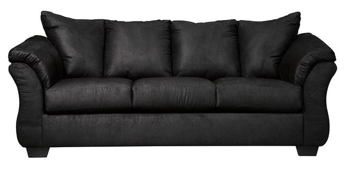 Full indoor shot of a black three-seat sofa. The sofa is a dark, solid black color. It features gently curved armrests and a slightly raised back, characteristic of a contemporary style. The cushions appear to be filled and are upholstered in the same material as the rest of the sofa. The sofa's lines are smooth and the overall impression is of a comfortable and modern piece of furniture. The sofa sits on four, visible, slightly angled, dark brown/black legs. The background is pure white, isolating the sofa as the central focus.