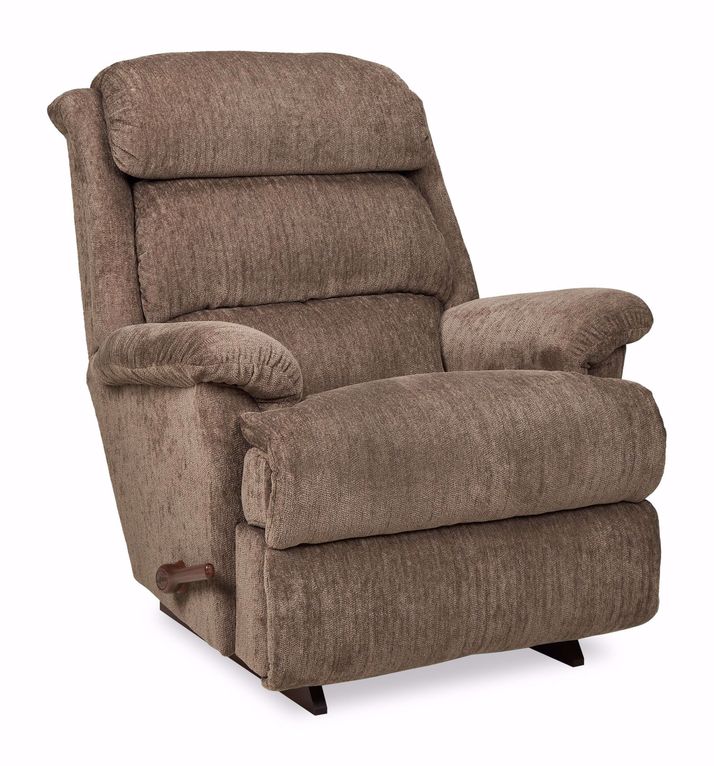 A light taupe-brown recliner chair is centered against a white background.    The chair has a padded back and seat with a textured fabric.  The back is slightly arched and has a tufted design. The armrests are oversized and upholstered in the same material as the rest of the chair.    The chair's base is a dark, wood-toned. The chair's design appears contemporary and supportive.