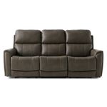 A contemporary three-seat power reclining sofa in a rich brown leather upholstery, featuring plush divided back cushions, flared pillow arms with subtle tufting, and sleek divided seats for enhanced comfort. The design includes adjustable headrests and lumbar pillows, a flip-down center console with cupholders and charging ports, all elevated on low block feet against a white studio background.