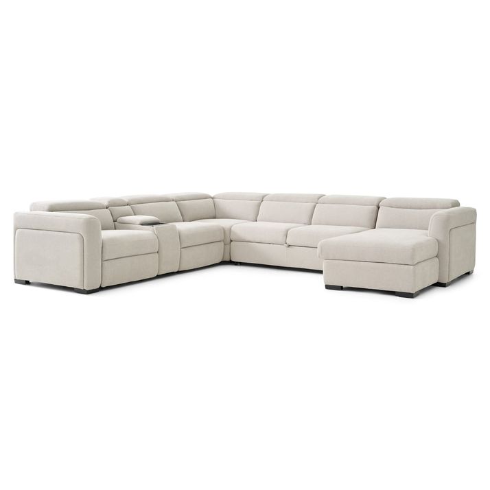 A light beige or cream-colored sectional sofa with a chaise lounge.   The sectional is an L-shape with multiple seating areas. The sofa has a modern design with clean lines, and the seating areas are padded, with visible cushioning. Each end of the sectional has armrests.   The sofa is presented against a plain white background, which allows the light beige color of the sofa to stand out clearly.