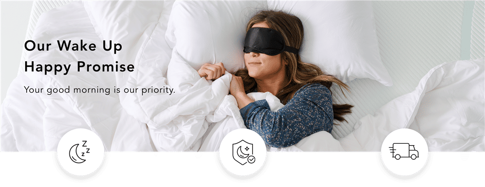 A women lays in bed with an eye mask, surrounded by white blankets.